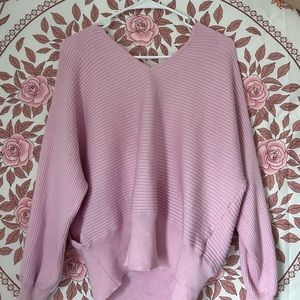 A size large pink sweater, with a low cross in the back. A little backless.
